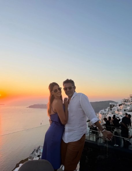 Φίλιππος Μιχόπουλος και Κωνσταντίνα Ευριπίδου ποζάρουν αγκαλιά με φόντο το ηλιοβασίλεμα της Σαντορίνης